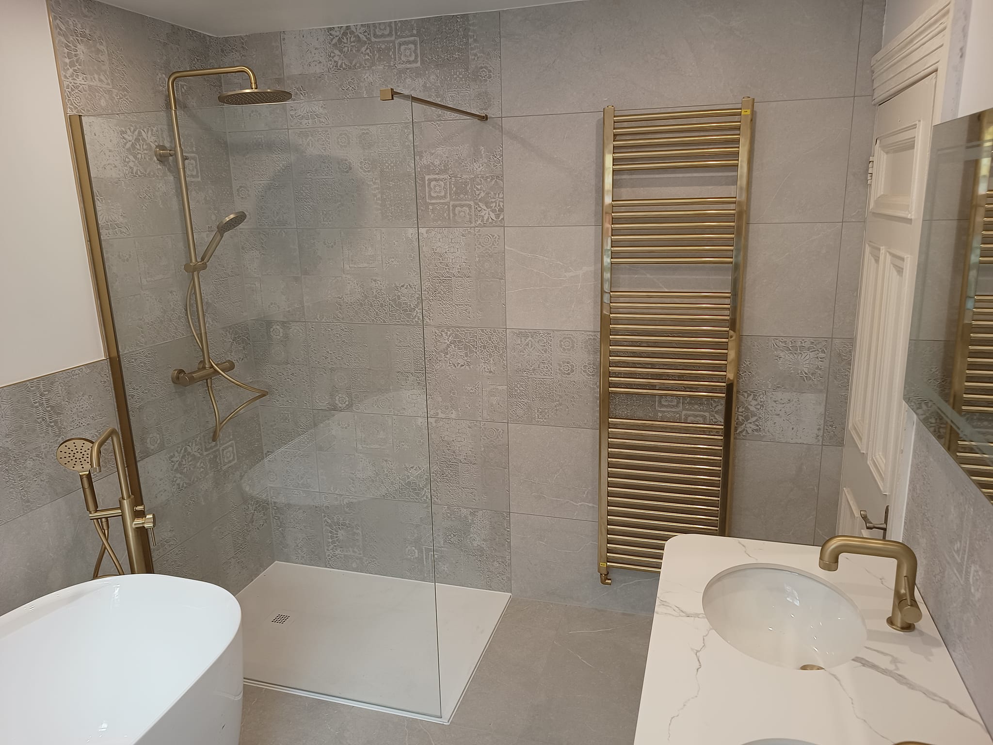 Patterned tiled bathroom with gold hardware