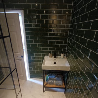 green tiled bathroom with black accents