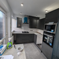 black kitchen with white marble counters